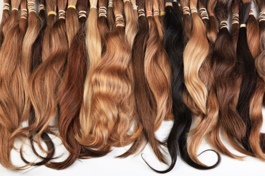 different color hair extensions laying down next to each other