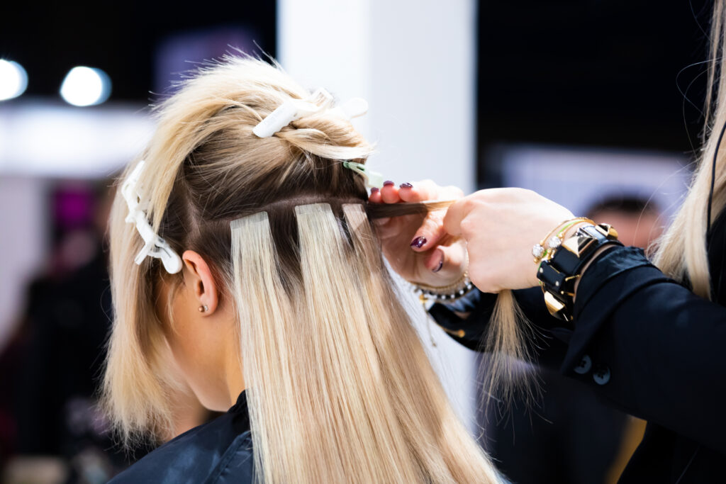 hair extensions being inserted on a blonde girl