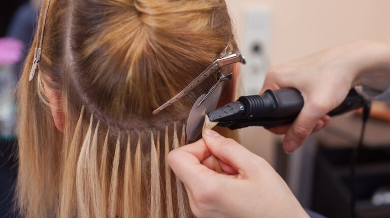 woman getting hair extensions installed on head