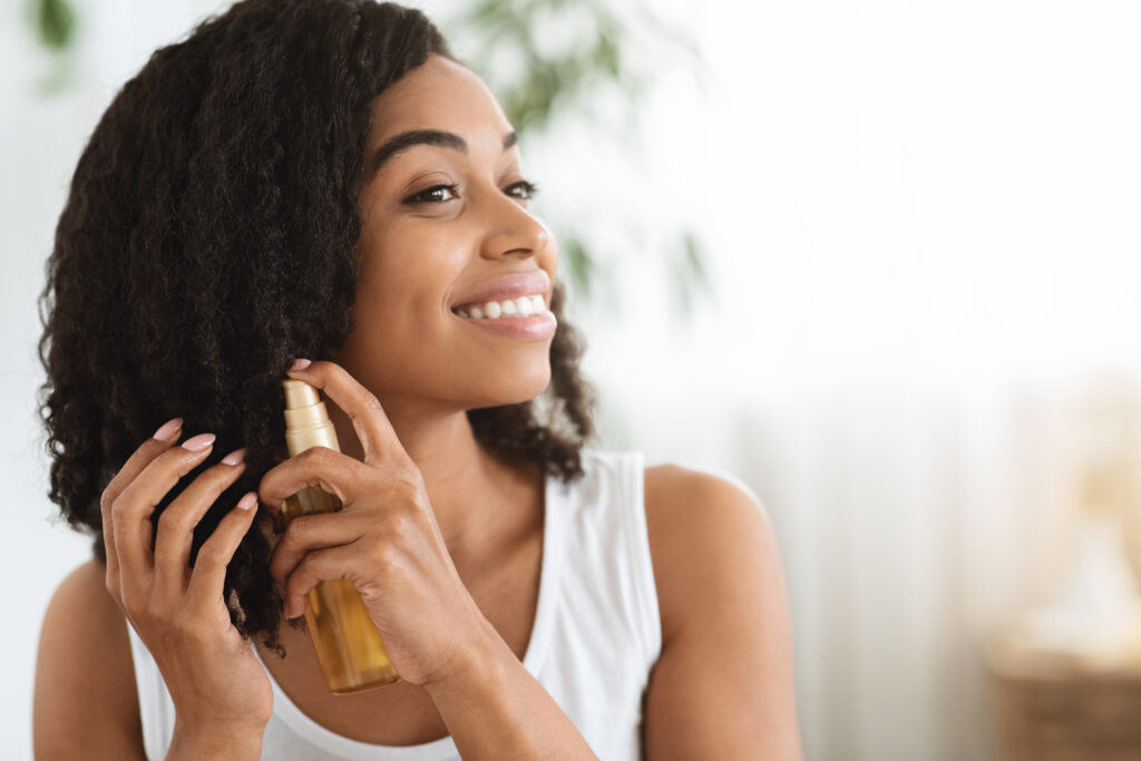 woman spraying her hair with natural hair care