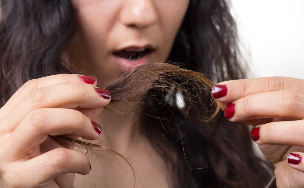 woman shocked with her mouth open looking at her split ends