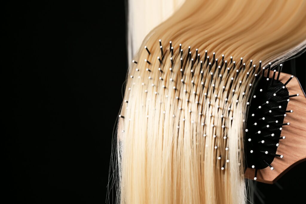 close up of brushing blonde hair extensions