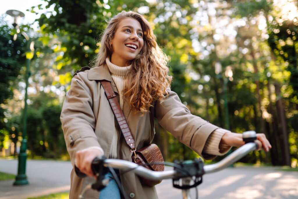 woman riding bike during the fall season with curly long hair