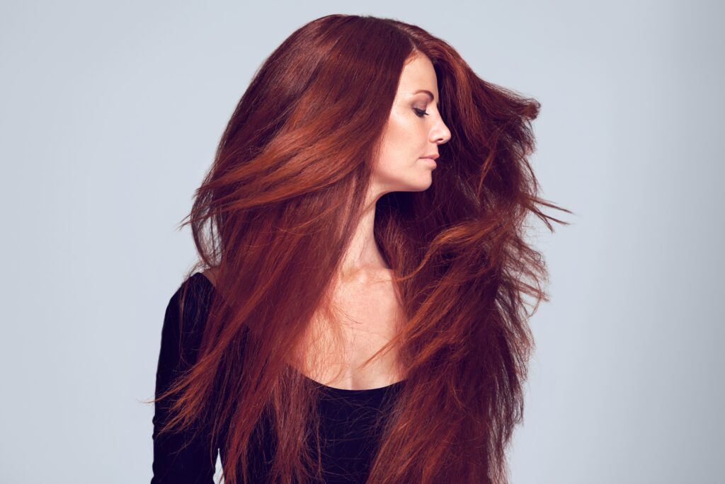 reddish/orange hair on woman as she turns her head it sways to show off the luscious strands