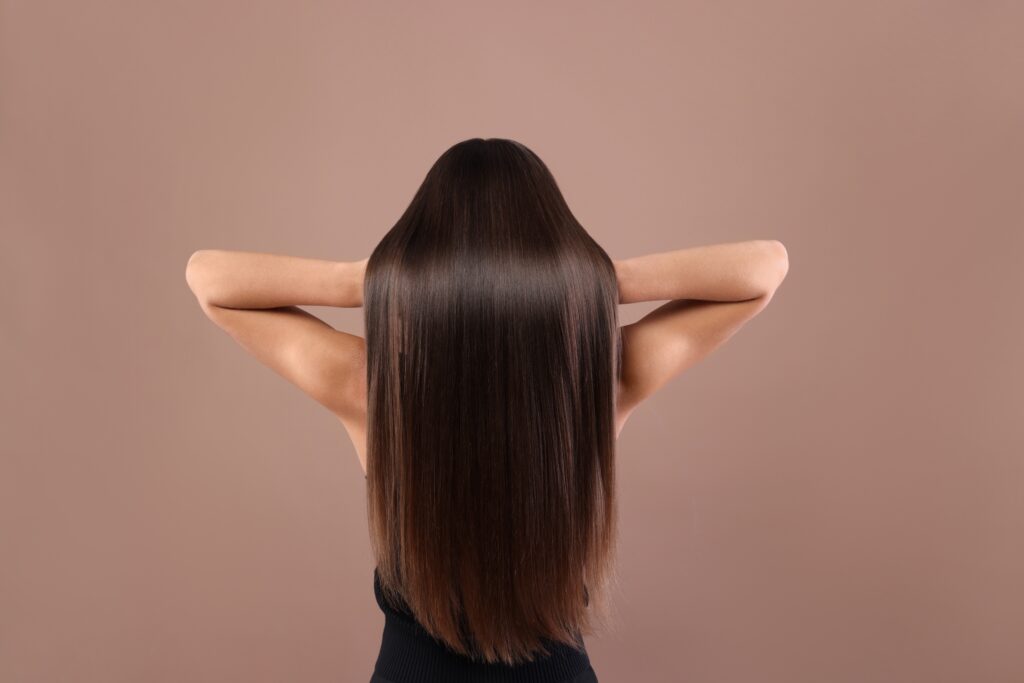 woman showing off long brown shiny hair